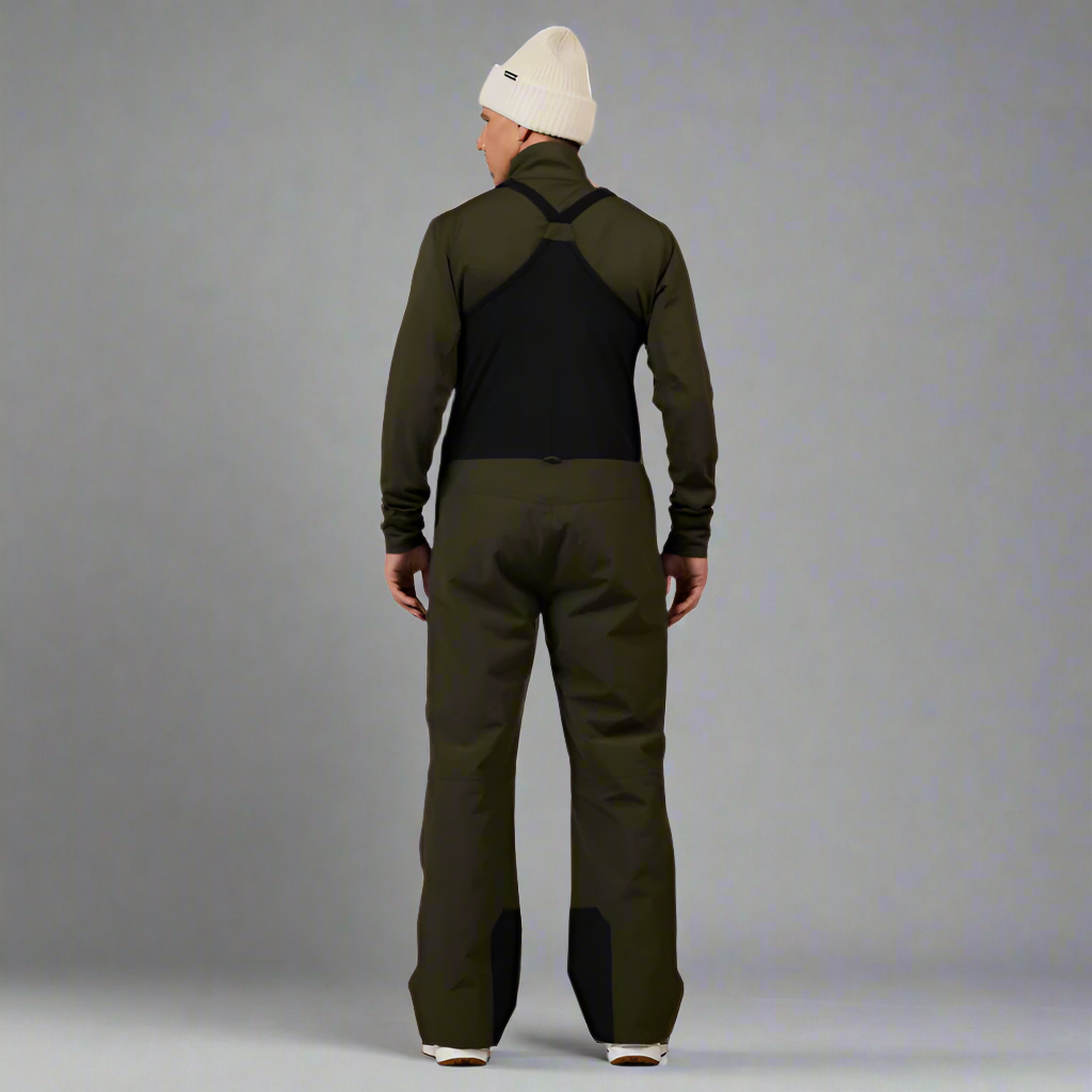 Person wearing a green jacket and pants with a white beanie on a white background