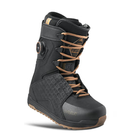 Black snowboard boot with brown laces on a white background