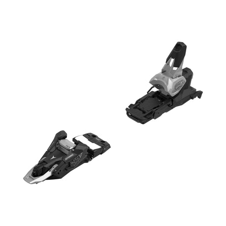A pair of ski bindings shown on a plain white background, one upright and one lying on its side. The bindings are primarily black with silver and white accents.