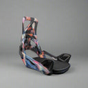 Multicolored snowboard binding on a textured surface with a neutral background