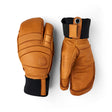 A pair of brown leather winter gloves shown from the back and side on a white background. The gloves feature a warm brown leather body with black cuffs and a small circular metal grommet on the wrist strap.