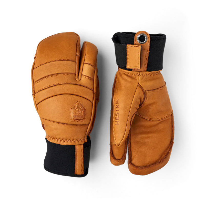 A pair of brown leather winter gloves shown from the back and side on a white background. The gloves feature a warm brown leather body with black cuffs and a small circular metal grommet on the wrist strap.