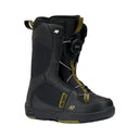 Black snowboard boot with green accents on a white background