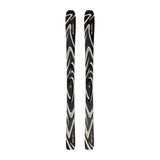 A pair of skis with a black base featuring a swirling zebra-like pattern in beige and white, with small red and orange logo details near the tips.