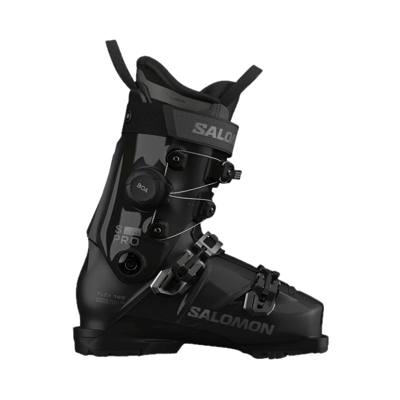 A Salomon ski boot in black with gold accents, featuring a dial closure system and a quick-release buckle, shown from a side profile on a white background.