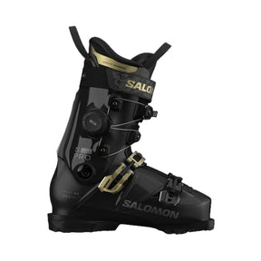 A Salomon ski boot in black with gold accents, featuring a dial closure system and a quick-release buckle, shown from a side profile on a white background.