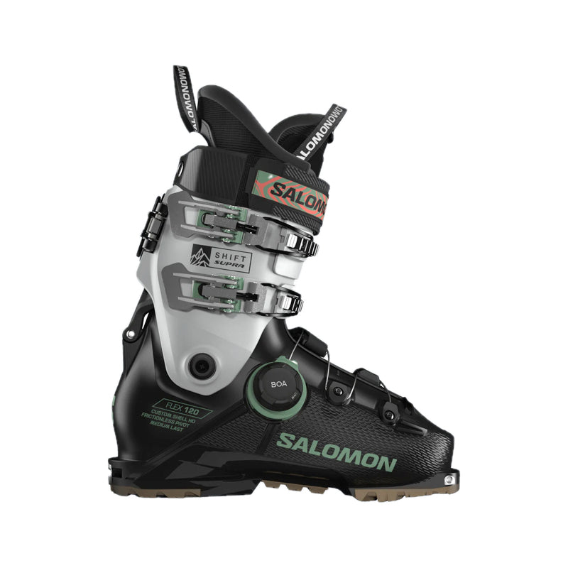 Salomon ski boot in black and silver with green accents, featuring a dial closure system and quick-release buckles, shown from a side profile on a white background.