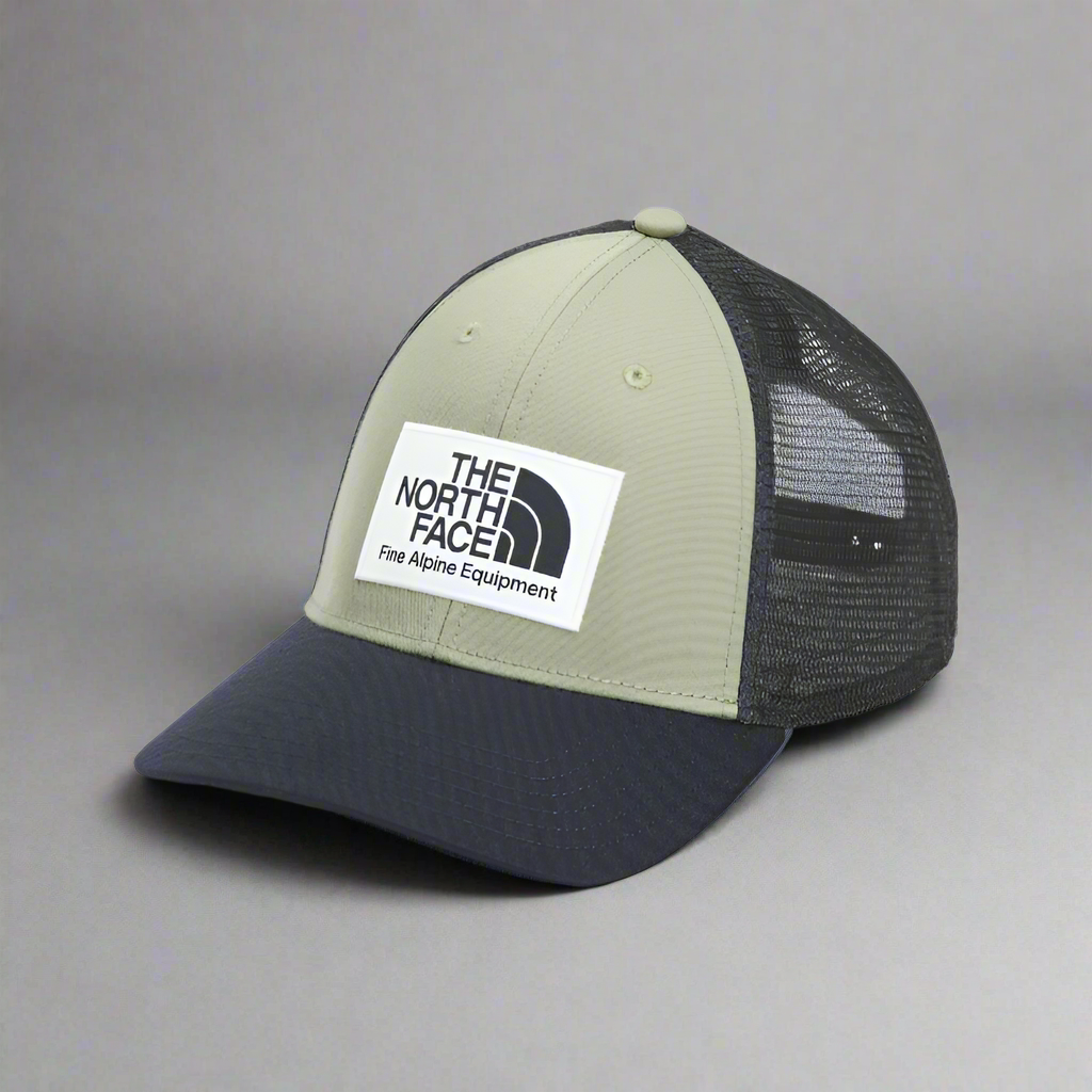 Green and navy cap with The North Face logo on a white background