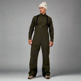 Person wearing a green bib overalls and white beanie on a white background