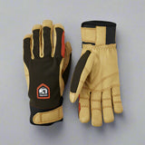 Pair of green and tan work gloves on a grey background