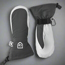 Pair of grey and white mittens with a visible Hestra logo on a grey background