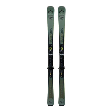 Pair of green skis with bindings on a light gray background
